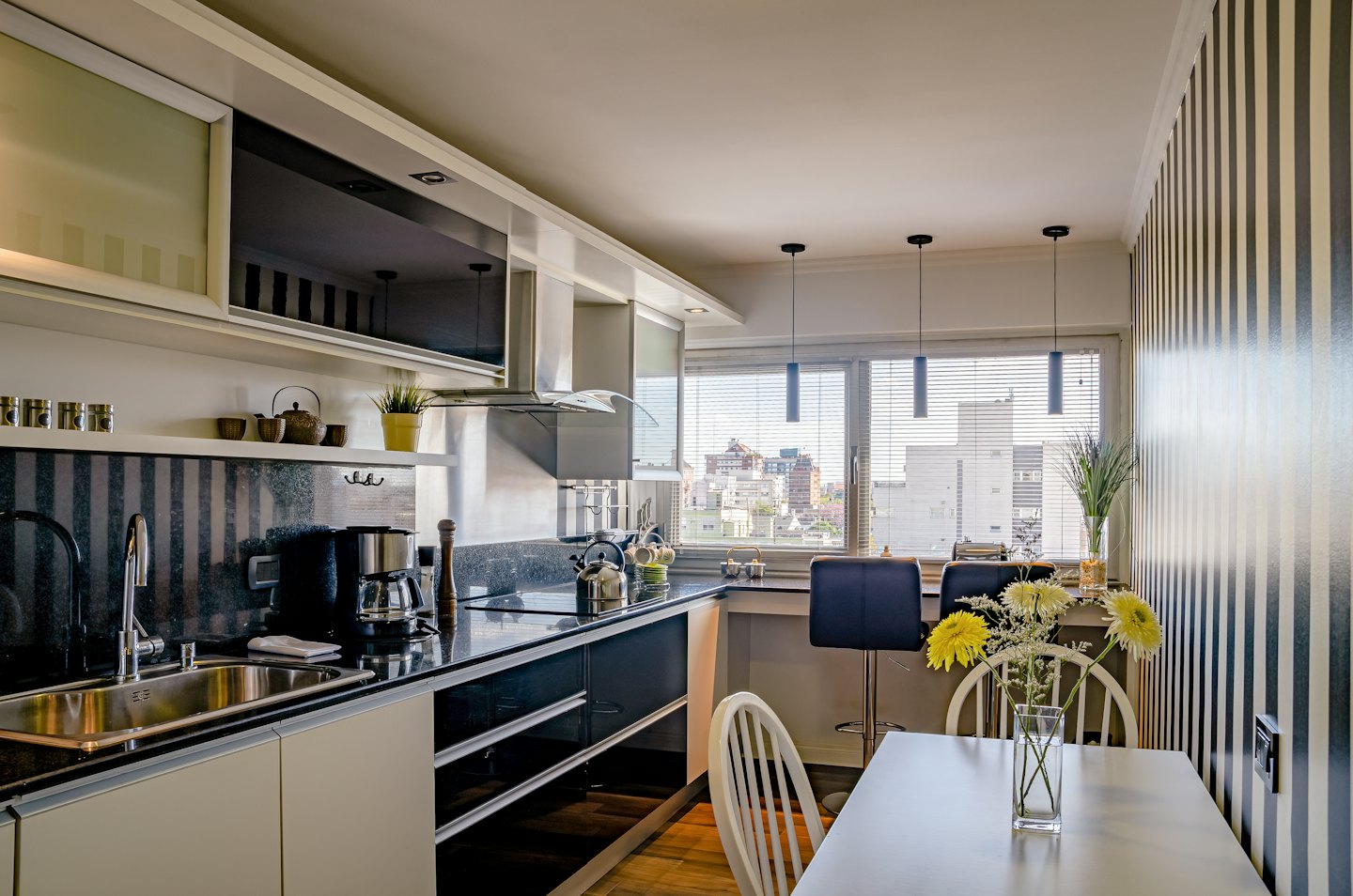 Nowoczesna kuchnia i jadalnia w apartamencie ze sprzętem ze stali nierdzewnej.